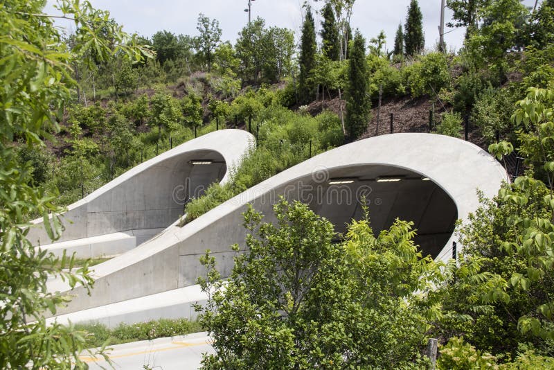Attraktiva tunneler ?ver huvudv?gen i Tulsa Oklahoma n?ra parkerar och Arkansas River med m?nga st?ttade unga tr?d, som de v?xer arkivfoton Attraktiva tunneler ?ver huvudv?gen i Tulsa Oklahoma n?ra parkerar och Arkansas River med m?nga st?ttade unga tr?d, som de v?xer arkivfoton
