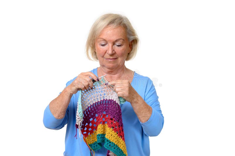 Attraktive blonde ältere Dame, die ihr Stricken tut lizenzfreie stockfotos Attraktive blonde ältere Dame, die ihr Stricken tut lizenzfreie stockfotos