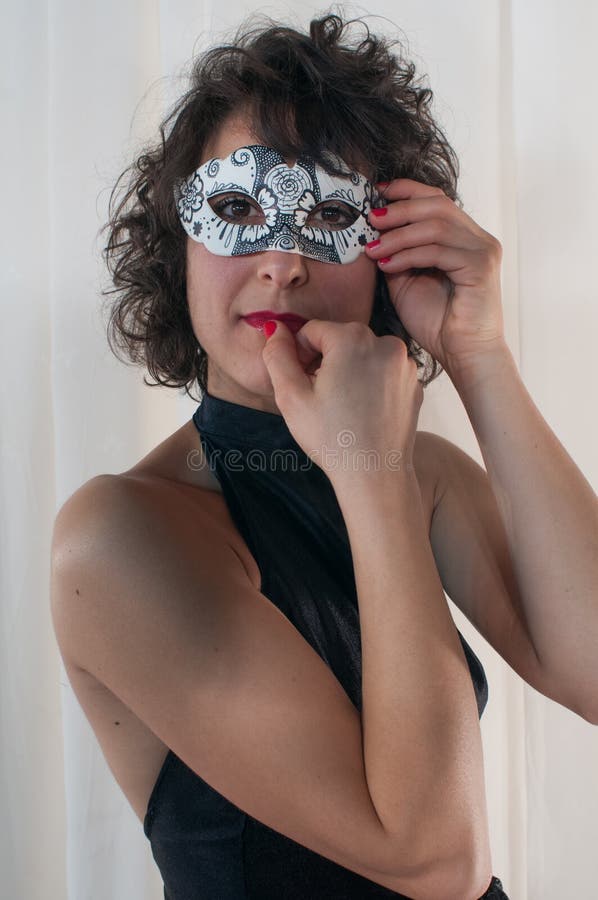 Attraktive Frau, die mit Karnevals-Maske lächelt stockfoto Attraktive Frau, die mit Karnevals-Maske lächelt stockfoto