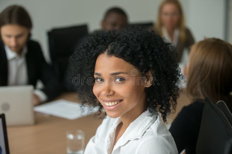 African american attractive businesswoman at meeting, smiling black employee, team leader or professional manager looking at camera, young women business coach or corporate teacher head shot portrait. African american attractive businesswoman at meeting, smiling black employee, team leader or professional manager looking at camera, young women business coach or corporate teacher head shot portrait