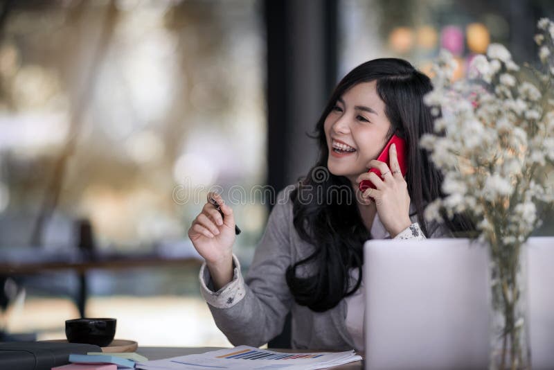 Attraktive junge asiatische Geschäftsfrau, die auf dem beweglichen Phon spricht lizenzfreies stockbild Attraktive junge asiatische Geschäftsfrau, die auf dem beweglichen Phon spricht lizenzfreies stockbild