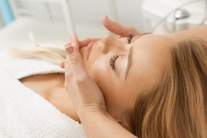 Attraktive junge Frau, die Gesichtsmassage am Badekurort erhält stockfotos Attraktive junge Frau, die Gesichtsmassage am Badekurort erhält stockfotos