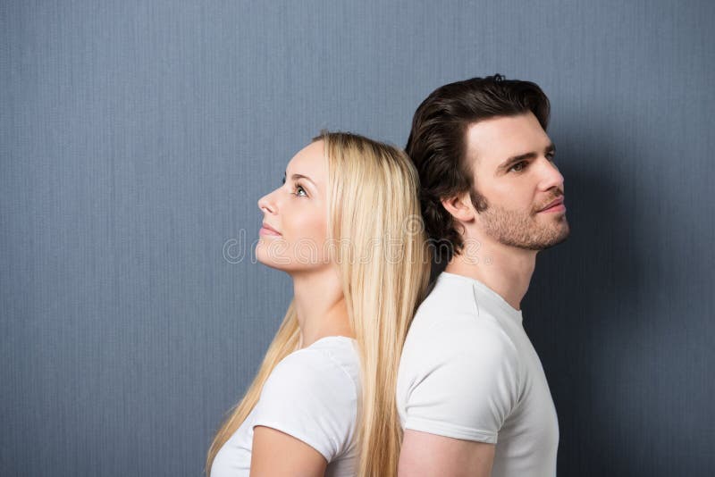 Attraktive junge Paare, die zurück zu Rückseite stehen stockfotografie