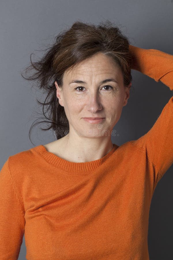 Attraktive mittlere Greisin, die ihr sexy langes braunes Haar hält lizenzfreie stockfotografie Attraktive mittlere Greisin, die ihr sexy langes braunes Haar hält lizenzfreie stockfotografie