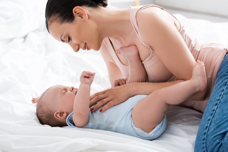 Attraktive Mutter, die Auffassung schreiendes Baby stockbilder