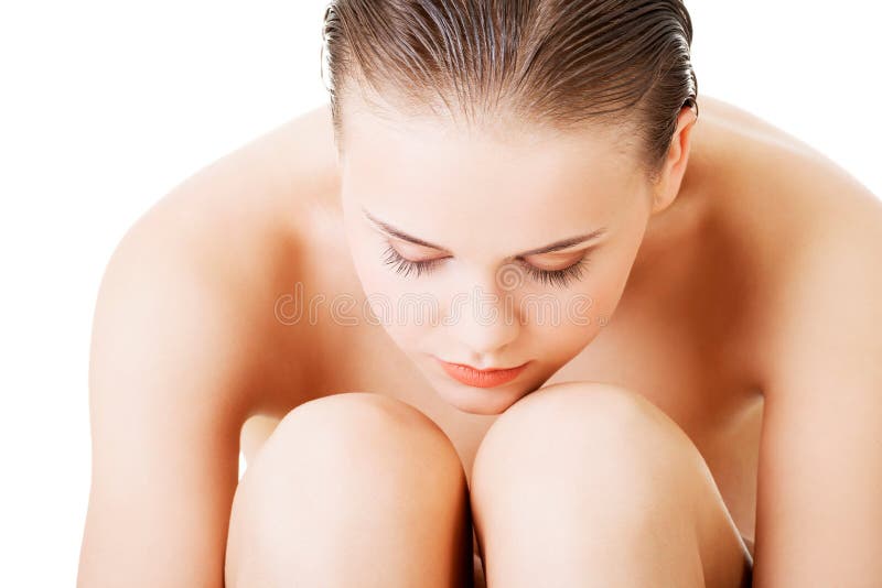 Attraktive nackte Frau, die halten sitzt. Nahaufnahme. lizenzfreie stockfotografie Attraktive nackte Frau, die halten sitzt. Nahaufnahme. lizenzfreie stockfotografie