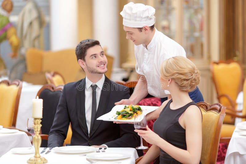 Attraktive Paare, die Luxusrestaurant besichtigen lizenzfreie stockbilder Attraktive Paare, die Luxusrestaurant besichtigen lizenzfreie stockbilder