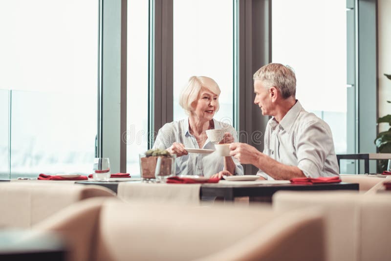 Attraktive Paare im Ruhestand, die in einem Café zusammen frühstücken stockfotografie Attraktive Paare im Ruhestand, die in einem Café zusammen frühstücken stockfotografie