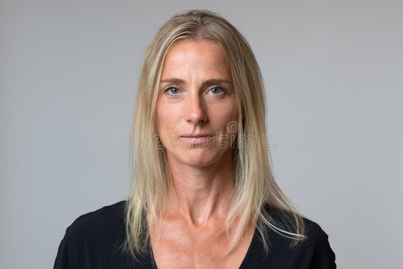 Attraktive ruhige blonde Frau mit einem ruhigen Lächeln lizenzfreie stockbilder Attraktive ruhige blonde Frau mit einem ruhigen Lächeln lizenzfreie stockbilder