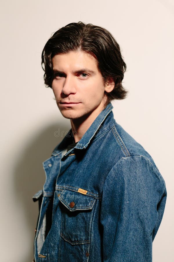 Attraktiver junger Mann in einer Jeansjacke lizenzfreie stockfotos Attraktiver junger Mann in einer Jeansjacke lizenzfreie stockfotos