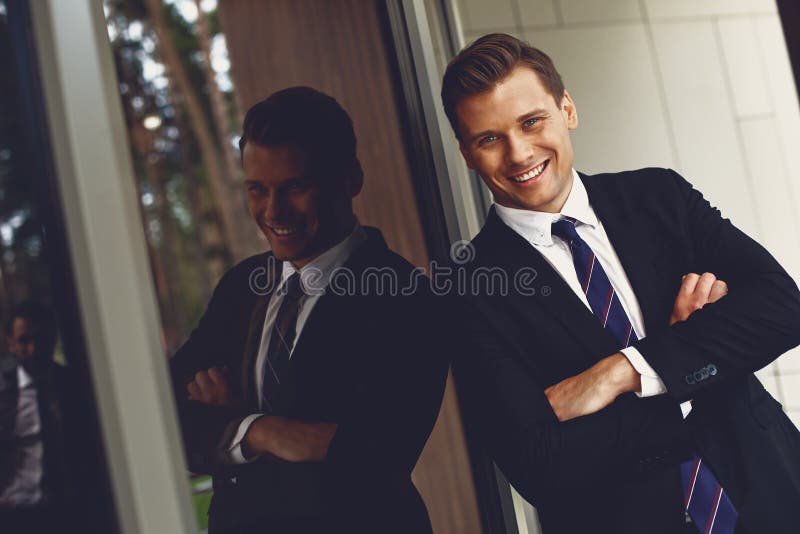 Attraktiver junger Mann lächelt und sieht zuversichtlich aus lizenzfreies stockfoto Attraktiver junger Mann lächelt und sieht zuversichtlich aus lizenzfreies stockfoto