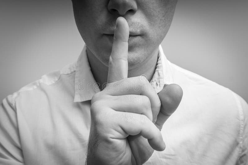 Attraktiver Mann mit dem Finger auf den Lippen, die Ruhegeste machen lizenzfreie stockfotos Attraktiver Mann mit dem Finger auf den Lippen, die Ruhegeste machen lizenzfreie stockfotos