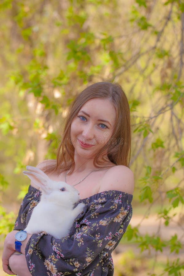 Attraktives Mädchen mit einem weißen Magic und fantastischen Kaninchen Ostern stockfotografie