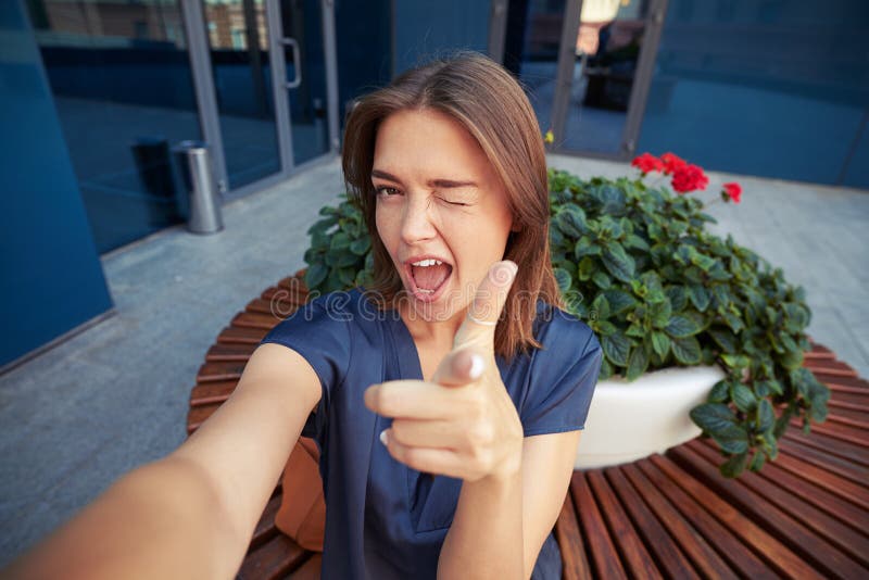Attraktivt kvinnligt blinka på kameran, medan posera för en selfi arkivbilder Attraktivt kvinnligt blinka på kameran, medan posera för en selfi arkivbilder
