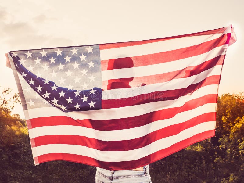 Attrayant, jeune homme tenant un drapeau des USA photo stock Attrayant, jeune homme tenant un drapeau des USA photo stock