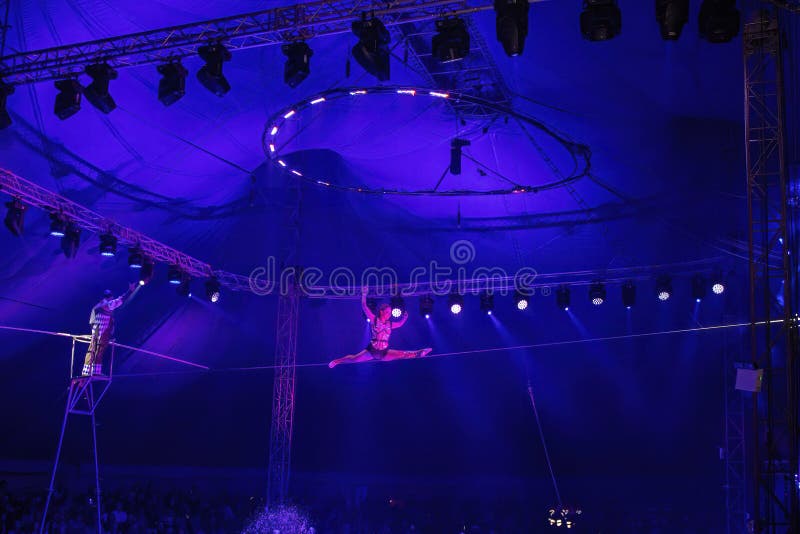 Attrice del circo acrobata si esibisce sulle funi. una ragazza esegue elementi acrobatici nell'aria fotografia stock
