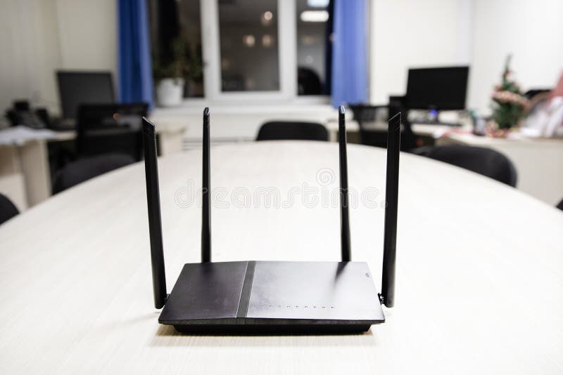 Au centre du cadre est le routeur dans le noir sur une table en bois légère, accès à l'Internet dans cette chambre photo libre de droits Au centre du cadre est le routeur dans le noir sur une table en bois légère, accès à l'Internet dans cette chambre photo libre de droits
