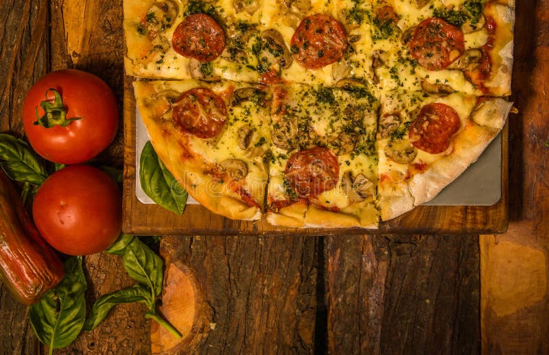 Au-dessus de la vue des tomates près d'une pizza délicieuse sur le fond en bois de table à la maison tout préparé photographie stock Au-dessus de la vue des tomates près d'une pizza délicieuse sur le fond en bois de table à la maison tout préparé photographie stock