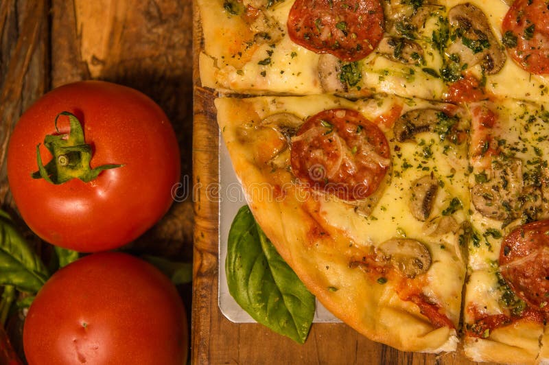 Au-dessus de la vue des tomates près d'une pizza délicieuse sur le fond en bois de table à la maison tout préparé photographie stock Au-dessus de la vue des tomates près d'une pizza délicieuse sur le fond en bois de table à la maison tout préparé photographie stock