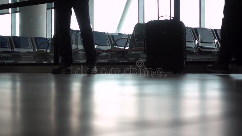 Au rez-de-chaussée soft focus vidéo clip de personnes anonymes marchant à travers un terminal d'aéroport avec valises et bagages