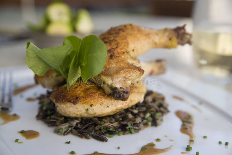 Crispy Game Hen on a bed of Wild Rice with Au Jus and Brussell Sprouts. Crispy Game Hen on a bed of Wild Rice with Au Jus and Brussell Sprouts