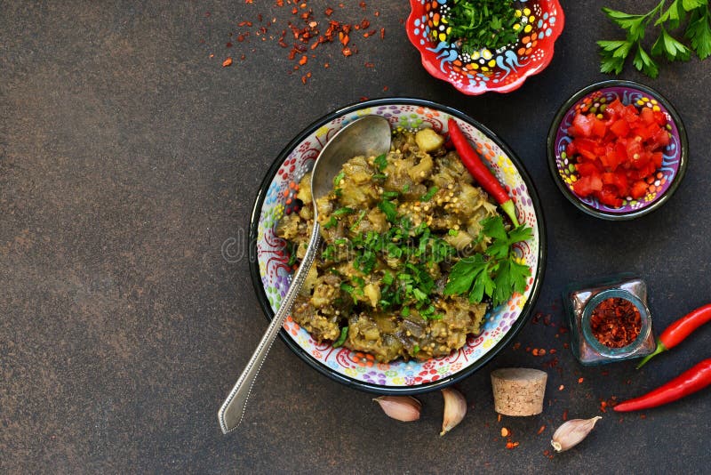 Aubergine sautée Salade des aubergines cuites au four sur un fond foncé images libres de droits Aubergine sautée Salade des aubergines cuites au four sur un fond foncé images libres de droits