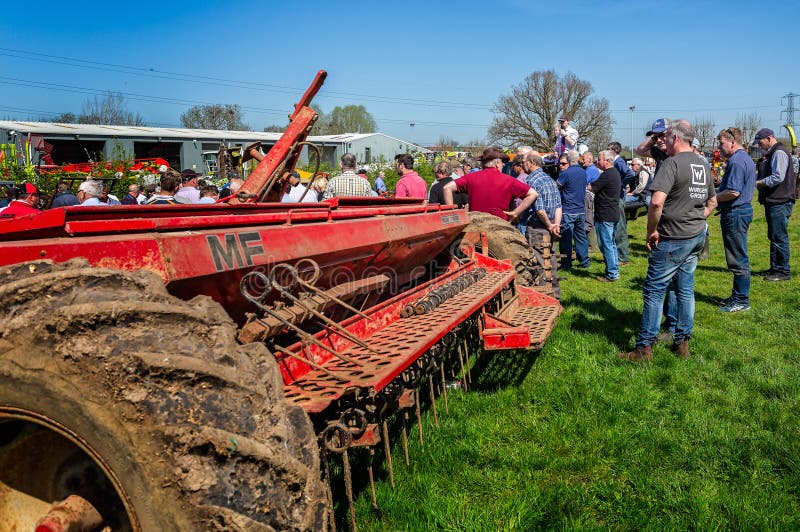 Auctioneer selling farming equipment at outdoor auction