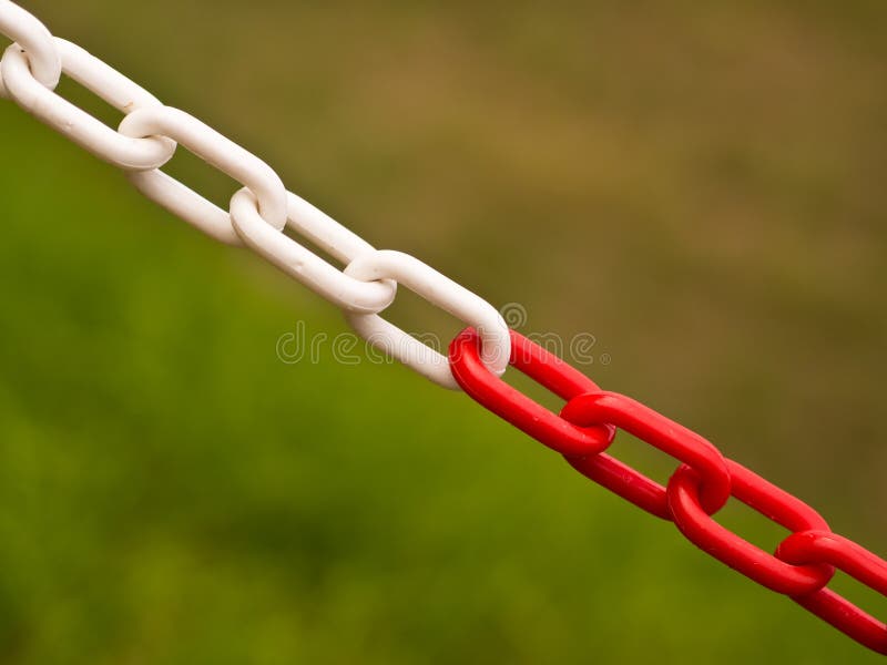 Red and white chain barring entrance to a private property, with a blurred background. Red and white chain barring entrance to a private property, with a blurred background.