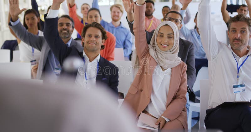 Audiencia en una presentaciÃ³n de negocios levantando la mano para hacer preguntas