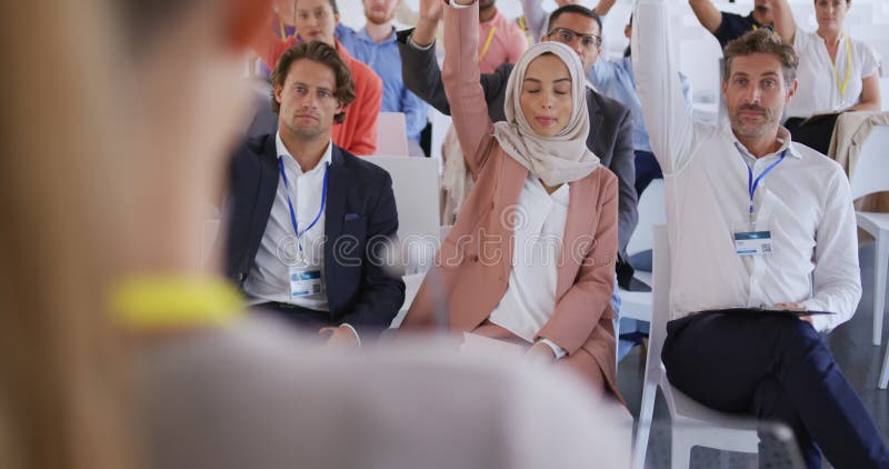 Audiencia en una presentaciÃ³n de negocios levantando la mano para hacer preguntas