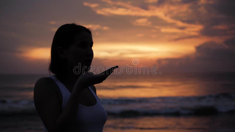 Audiomitteilung ai-Spracherkennung auf freihändiger Rede des Smartphone Junge schöne glückliche Frau des Sonnenuntergangschattenb