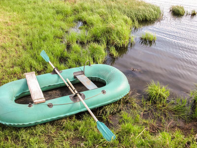 Aufblasbares Boot auf dem grünen Gras durch den See stockfotografie Aufblasbares Boot auf dem grünen Gras durch den See stockfotografie