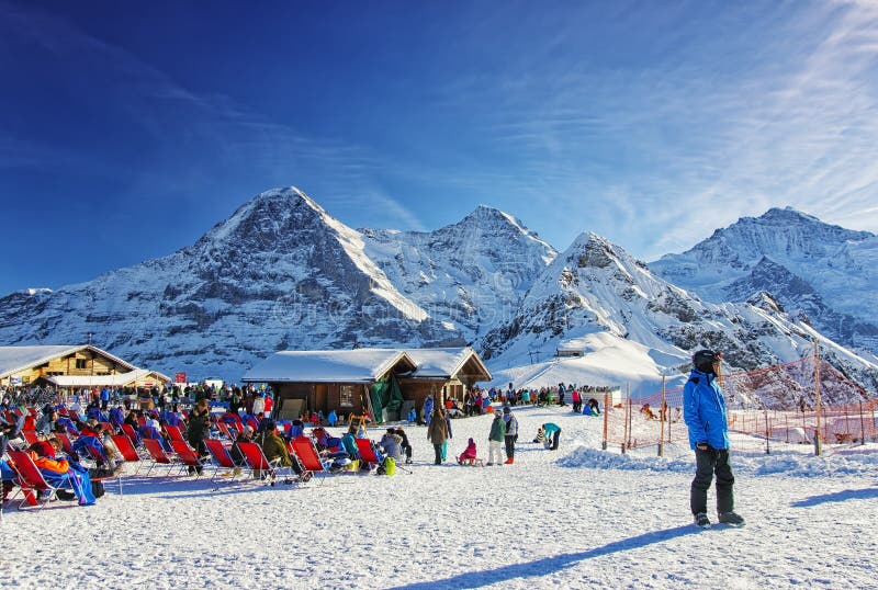 People relaxating at the outdoor lounge on highland winter sport resort in swiss alps. People relaxating at the outdoor lounge on highland winter sport resort in swiss alps