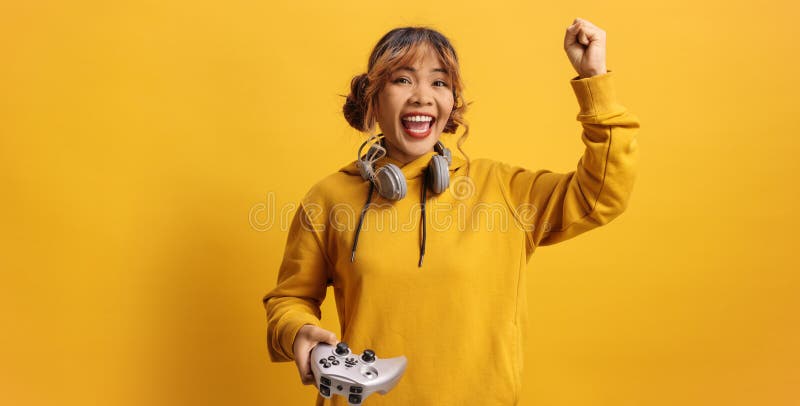 Aufgeregte asiatische Frau, die Videospiele mit einem Joystick spielt stockbild