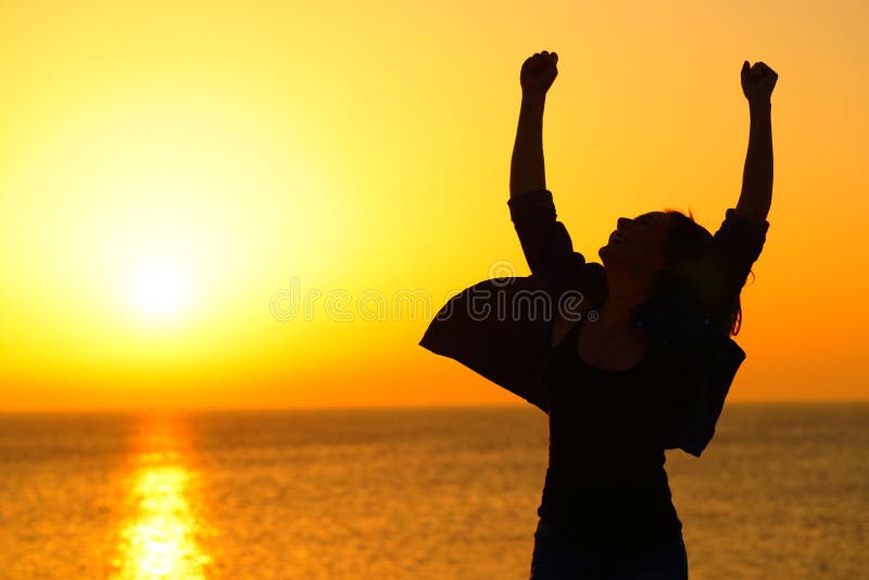 Excited woman silhouette celebrating success at sunrise on the beach. Excited woman silhouette celebrating success at sunrise on the beach