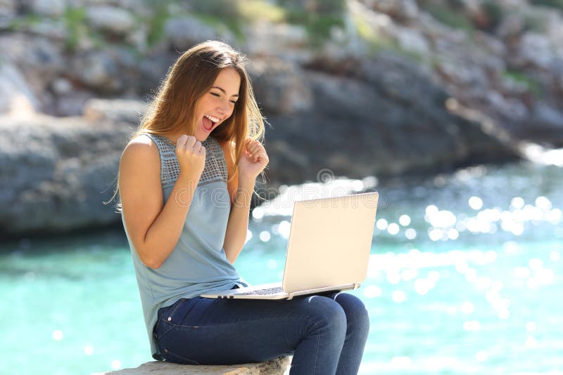 Aufgeregte Frau, die on-line-Angebot auf dem Strand findet