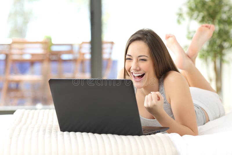 Aufgeregte Frau, die online aufpassenden Laptop gewinnt