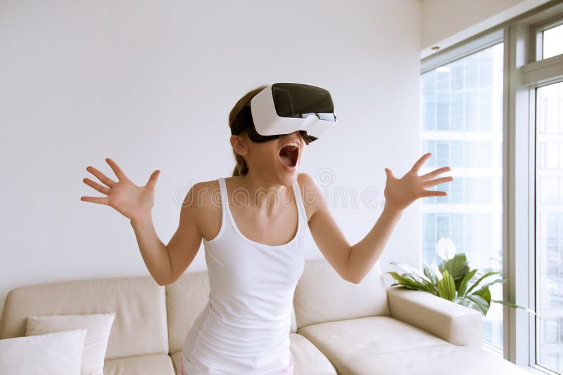 Excited young woman wearing virtual reality glasses and screaming because of unbelievable effects in 3d digital world. Impressed lady yelling and gesturing when using VR technology for the first time. Excited young woman wearing virtual reality glasses and screaming because of unbelievable effects in 3d digital world. Impressed lady yelling and gesturing when using VR technology for the first time