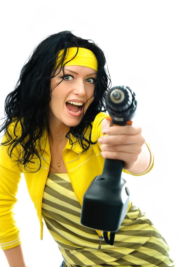 Beautiful young excited woman holding a drill in her hand isolated against white background. Beautiful young excited woman holding a drill in her hand isolated against white background