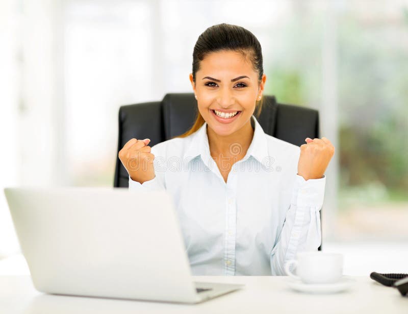 Excited businesswoman waving fists in office. Excited businesswoman waving fists in office