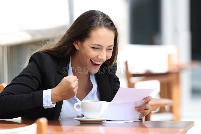 Excited businesswoman reading a letter sitting in a coffee shop outdoors. Excited businesswoman reading a letter sitting in a coffee shop outdoors