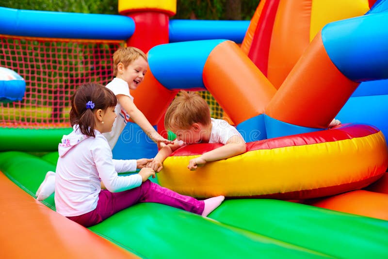 Group of excited kids having fun on inflatable attraction playground. Group of excited kids having fun on inflatable attraction playground