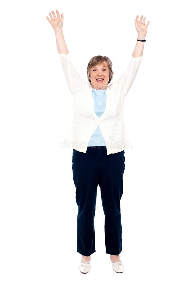 Excited senior woman posing with raised arms. Enjoying herself. Excited senior woman posing with raised arms. Enjoying herself