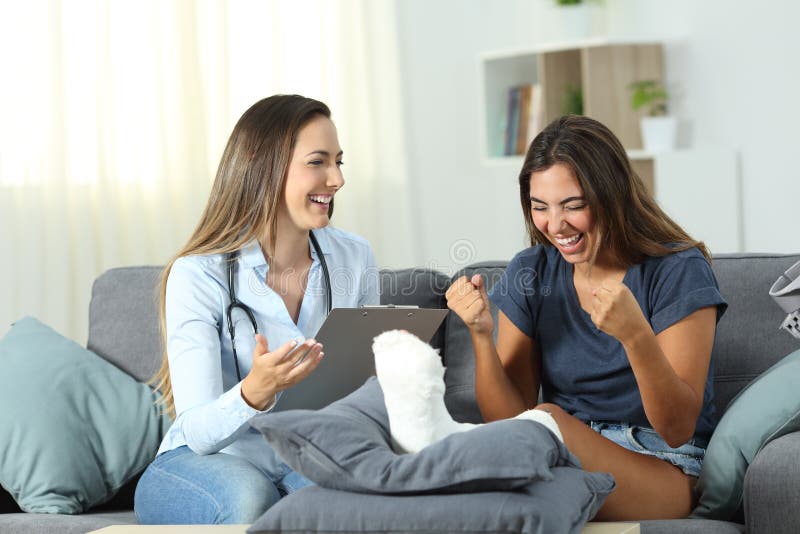 Excited patient receiving good news from a doctor sitting on a couch in the living room at home. Excited patient receiving good news from a doctor sitting on a couch in the living room at home