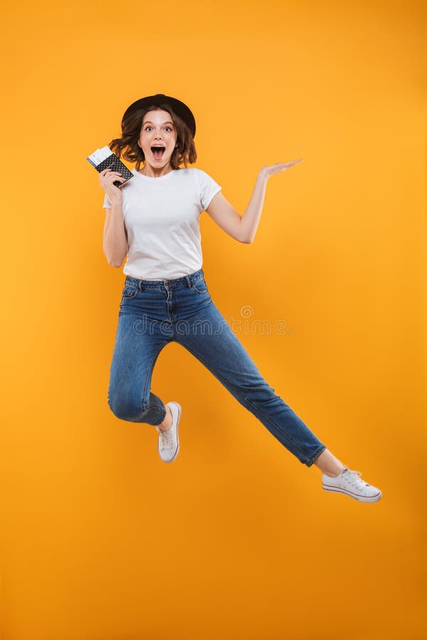 Aufgeregtes emotionales Touristenspringen der jungen Frau lokalisiert lizenzfreies stockbild Aufgeregtes emotionales Touristenspringen der jungen Frau lokalisiert lizenzfreies stockbild