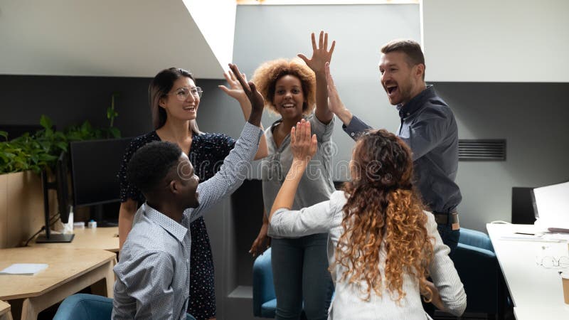 Excited euphoric multiracial business team give high five in office celebrate company growth, corporate success, help in goal achievement, good teamwork result, teambuilding partnership power concept. Excited euphoric multiracial business team give high five in office celebrate company growth, corporate success, help in goal achievement, good teamwork result, teambuilding partnership power concept