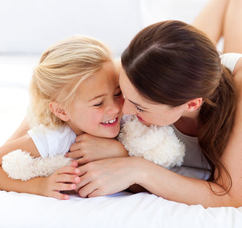 Aufmerksame Mutter, die ihre Tochter umarmt lizenzfreies stockfoto Aufmerksame Mutter, die ihre Tochter umarmt lizenzfreies stockfoto
