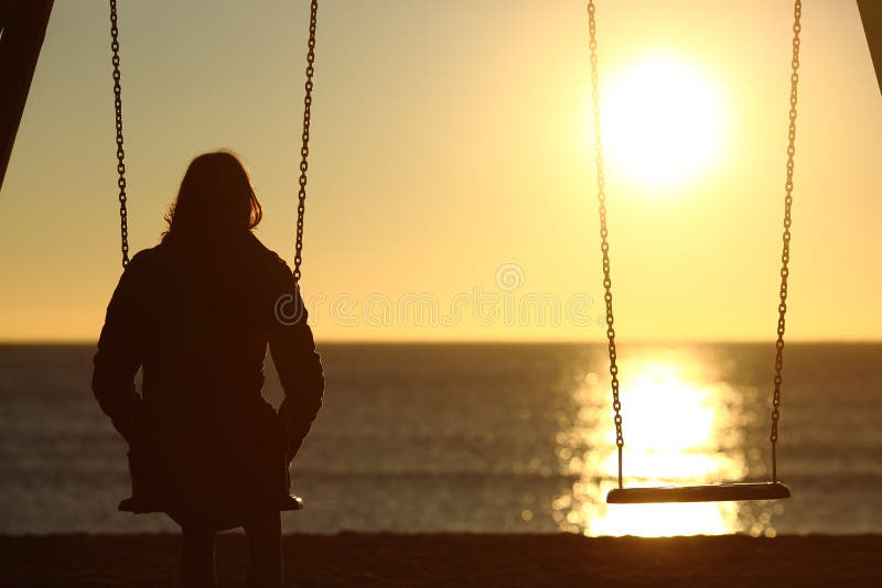 Aufpassender Sonnenuntergang der einsamen Frau allein im Winter