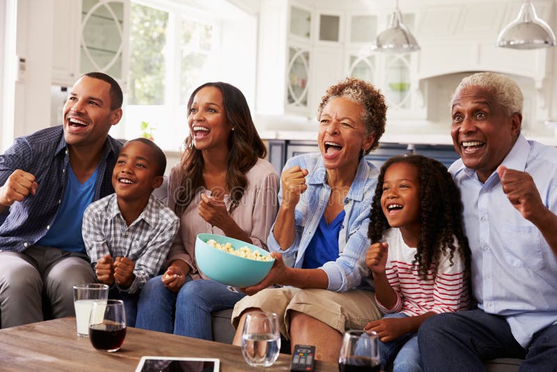 Aufpassender Sport der multi Generationsschwarz-Familie im Fernsehen zu Hause stockbilder