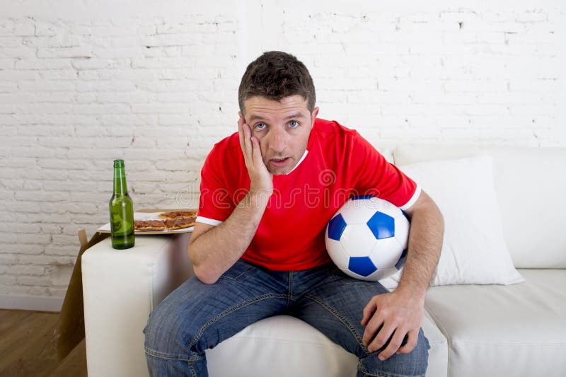 Aufpassendes Fußballspiel des Mannes des jungen Fans auf Fernsehdem tragenden Teamtrikotleiden nervös und Druck stockbild Aufpassendes Fußballspiel des Mannes des jungen Fans auf Fernsehdem tragenden Teamtrikotleiden nervös und Druck stockbild